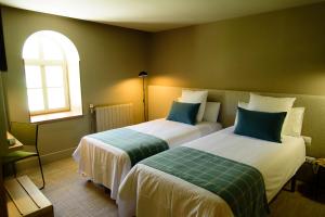 a hotel room with two beds and a window at Hotel Vall de Núria in Queralbs