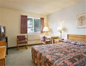ein Hotelzimmer mit einem Bett und einem Schreibtisch in der Unterkunft Sunset Inn & Suites in Lincoln