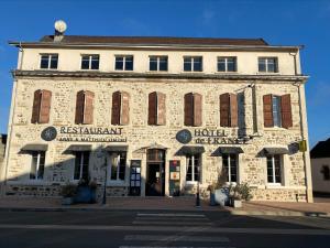 ein altes Steingebäude mit einem Hotel in einer Straße in der Unterkunft Hôtel de France in Montmarault