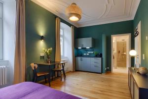 a bedroom with a bed and a table and a kitchen at homie stay am Schloss Apartments in Würzburg