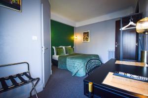 a hotel room with a bed and a desk at Hôtel Azur in Reims