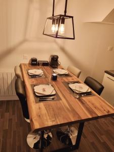 mesa de comedor con sillas y lámpara en Le bel'air appartement chaleureux et calme oyonnax, en Oyonnax