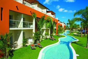 a resort with a swimming pool next to a building at Breathless Punta Cana Resort & Spa - Adults Only in Punta Cana