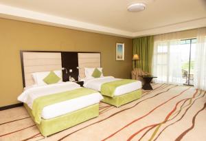 A bed or beds in a room at Crossroads Hotel Blantyre