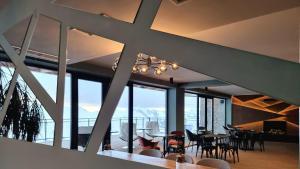 a dining room with tables and chairs and windows at Monte Hotel in Gudauri