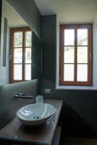 a bathroom with a sink and two windows at Hotel Vall de Núria in Queralbs