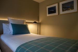 a bedroom with a bed with a blue pillow at Hotel Vall de Núria in Queralbs