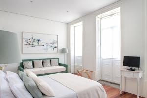 - une chambre blanche avec un lit et une télévision dans l'établissement Charming House Marquês, à Porto
