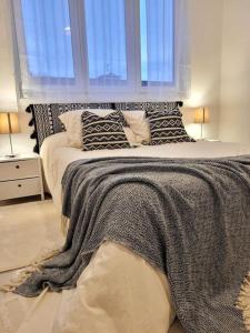 1 dormitorio con 1 cama grande con almohadas y ventana en Un écrin au cœur du centre ville en Dunkerque