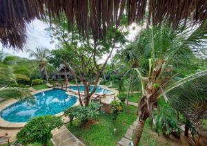 een uitzicht over een zwembad met een palmboom bij Marine Holiday House in Malindi