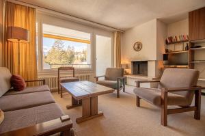 a living room with a couch and a table at Rothornblick 25 by Arosa Holiday in Arosa