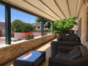 un patio cubierto con 2 sillas y una mesa en Logis L'Hôtel D'Arc, en Arc-sur-Tille