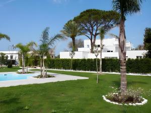 a park with palm trees and a swimming pool at Chiara's apartment Procida in Procida