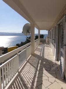 a balcony of a house with a view of the water at Apartments IVAN in Duce (900) in Duće