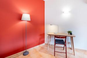 a table with a chair and a lamp in a room at Praia da Luz Monique Apartment in Luz