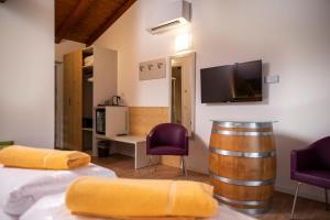 une chambre avec un tonneau de vin et deux chaises violettes dans l'établissement Maso Agritur Santa Lucia, à Dro