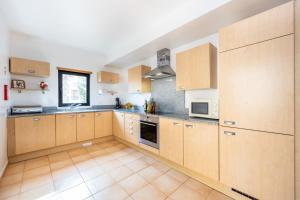 a large kitchen with wooden cabinets and appliances at Praia da Luz Monique Apartment in Luz
