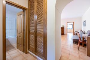 a hallway with a wooden door and a dining room at Praia da Luz Monique Apartment in Luz