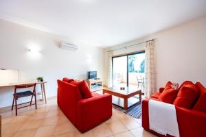 a living room with two red chairs and a table at Praia da Luz Monique Apartment in Luz