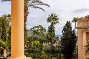 a view of the ocean from a building with a palm tree at Praia da Luz Monique Apartment in Luz