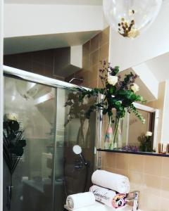 y baño con ducha con flores y toallas. en CANNES TOIT ET MOI en Cannes