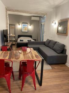 a living room with a couch and a table and red chairs at République - Dauder de Selva in Perpignan