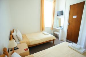 a hotel room with two beds and a television at Morrisy House in Blackpool