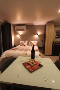 um quarto de hotel com uma mesa com dois copos de vinho em La chambre des Onglous em Marseillan