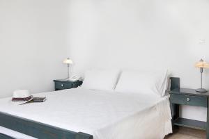 a bedroom with a large white bed with two night stands at San Antonio Summer House by GHH in Piso Livadi +21 photos