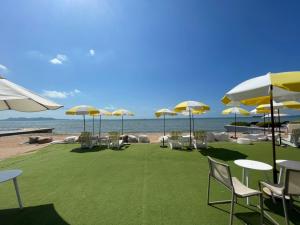 a group of chairs and tables with umbrellas on the beach at Veranda Residence By Hello Pattaya in Jomtien Beach +13 photos