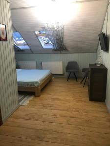 een slaapkamer met een bed, een bureau en 2 ramen bij Chalet Blanc in Boekovel