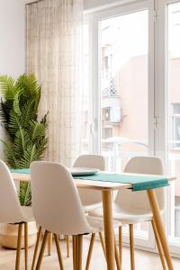 comedor con mesa y sillas blancas en Apartamento Nuevo Centro Granada, en Granada