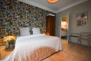 a bedroom with a bed with a floral wall at Hôtel Azur in Reims