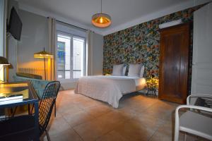 a bedroom with a bed with a floral wallpaper at Hôtel Azur in Reims
