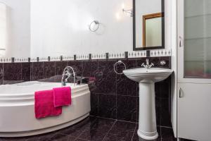 a bathroom with a white tub and a sink and a mirror at Xigia Escape villas in Khartáta
