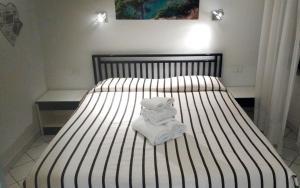 un letto bianco e nero con un asciugamano sopra di Residence Le Dune Club a Varigotti