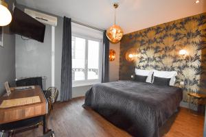 a bedroom with a bed and a desk and a window at Hôtel Azur in Reims