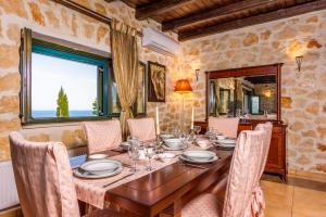 Xigia Escape villas في Khartáta: غرفة طعام مع طاولة وكراسي خشبية