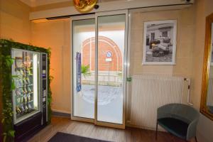 a glass door in a room with a window at Hôtel Azur in Reims