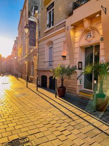 une rue pavée dans une ville avec des bâtiments dans l'établissement Hôtel Azur, à Reims