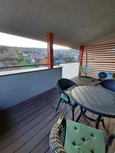 a balcony with a table and chairs on a deck at Apartman Kyjev in Podhájska