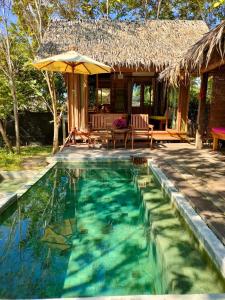 Casa con piscina y sombrilla en Thap Pala Cottage, en Songkhla