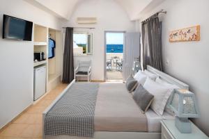 a bedroom with a bed and a view of the ocean at Akrotiri Hotel in Akrotiri