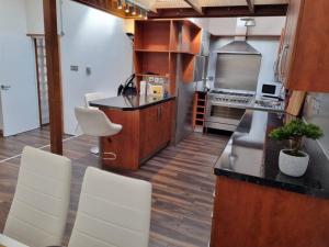 a kitchen with white chairs and a counter top at Modern and spacious two bedroom apartment in Ipswich