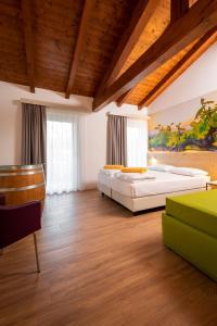 a bedroom with two beds and a wooden ceiling at Maso Agritur Santa Lucia in Dro