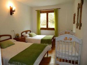 a bedroom with two beds and a window and a crib at Casa Rural Mantxoalorra in Ochagavía