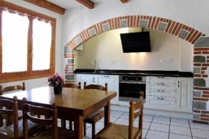 Una cocina con una mesa de madera y un comedor. en Casa Rural Mantxoalorra, en Ochagavía