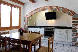 a kitchen with a wooden table and a dining room at Casa Rural Mantxoalorra in Ochagavía