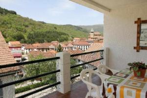 Un balcón con una mesa y vista a una ciudad. en Casa Rural Mantxoalorra, en Ochagavía