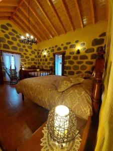 a bedroom with a bed and a table with a lamp at El Rincon del Nublo in Tejeda